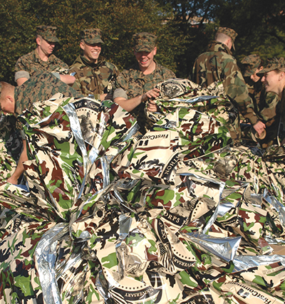 Marines hold camouflaged blankets they wore after the Marine Marathon