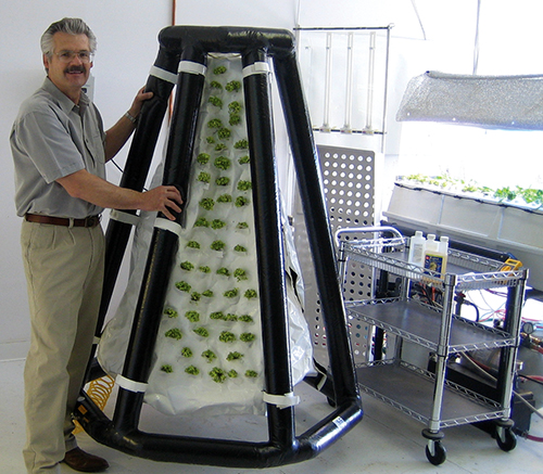 Richard Stoner II, the president of Agrihouse, next to an inflatable plant system