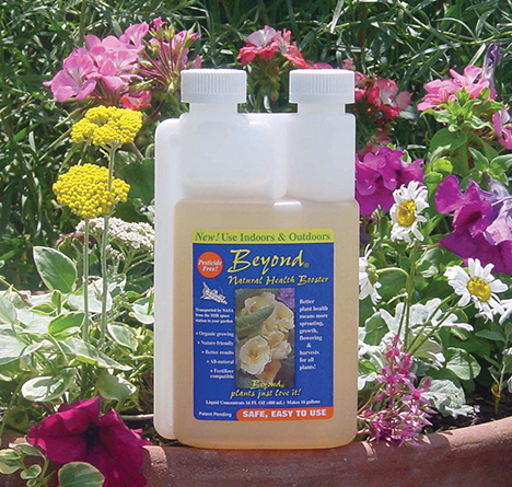 A bottle of Beyond all natural plant booster in front of wildflowers