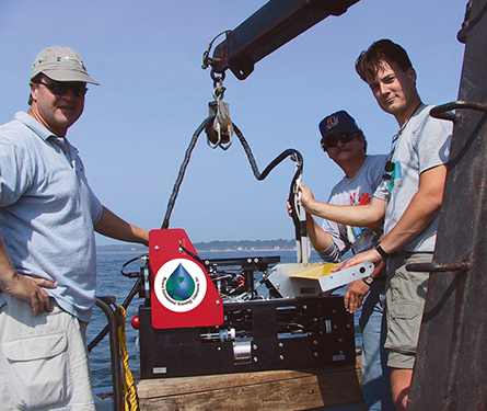 Three men with the DOLPHIN unit onboard a research vessel