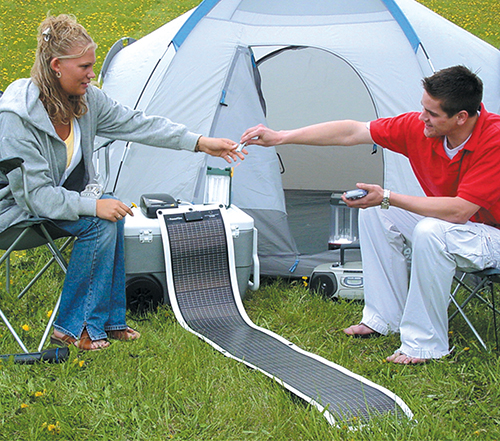 Two campers use a thin film solar solar charger as a power source
