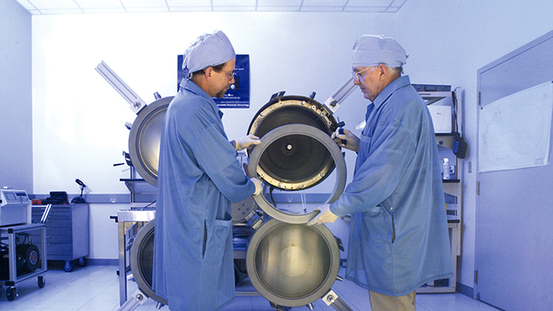 Two NASA engineers assemble a propulsion thruster for testing