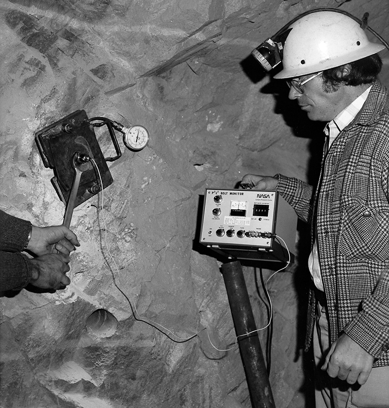 Deep within a mine shaft, Dr. Joseph Heyman looks on at early testing of NASA’s bolt elongation monitor