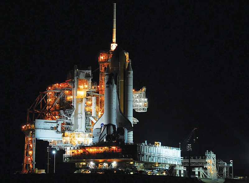 The space shuttle on the launch pad at night