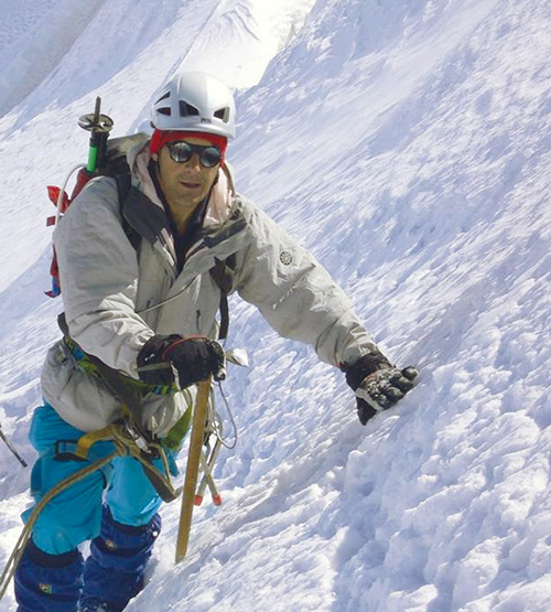 A mountain climber leans on a snowy slope