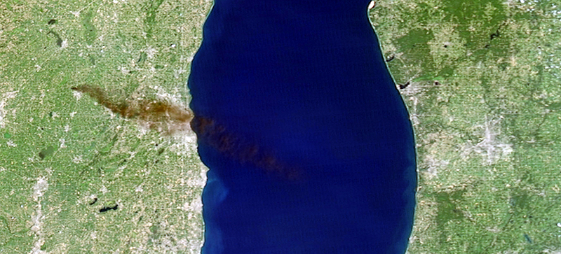 A satellite image shows smoke from a pile of burning tires on the western shore of Lake Michigan