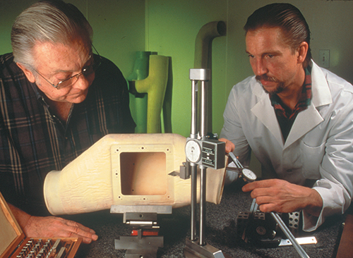 Two men conduct a quality control test on the Ultra Seal Duct component