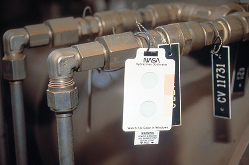 Badge hung on a pipe for use as a low-cost leak detector