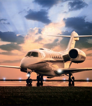 A Cessna business plane on the runway at sunset