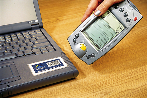 a hand-held device scanning a bar code on a laptop computer