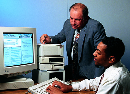 AnSim President Paul Patti watches as Jeffrey Meade demonstrates the graphical user interface
