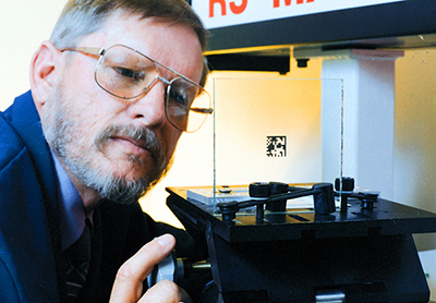 A man inspects laser-applied product labeling