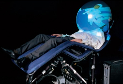 A man sits in a relaxation chair with his head inside of a bubble dome