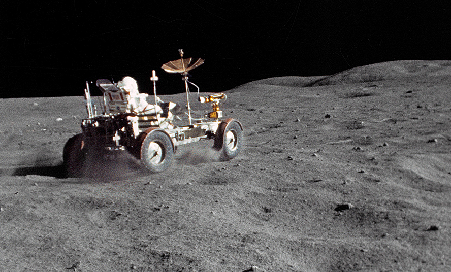 Apollo astronaut driving a rover on the moon