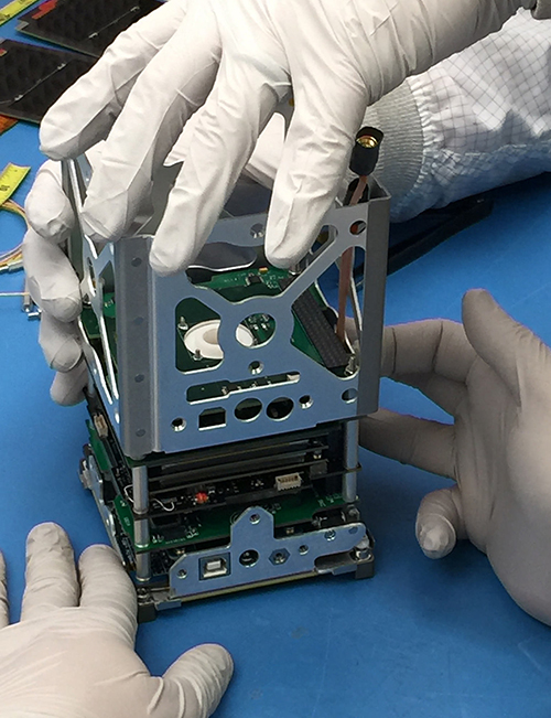 Closeup of a CubeSat being handled