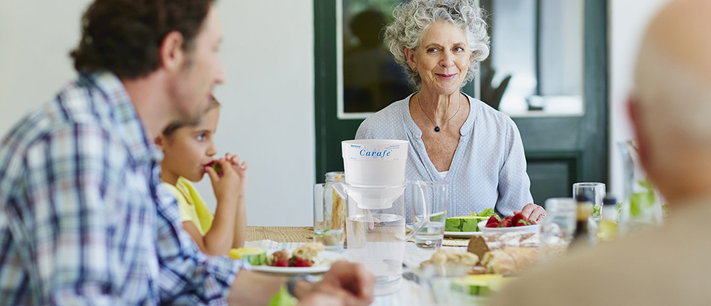 A family at mealtime with an Aquaspace Carafe Pitcher on the table