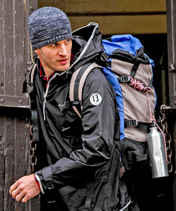 A hiker wears a 13-One jacket