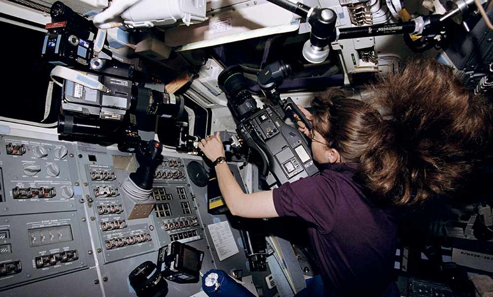 A woman uses a video camera on the space shuttle 