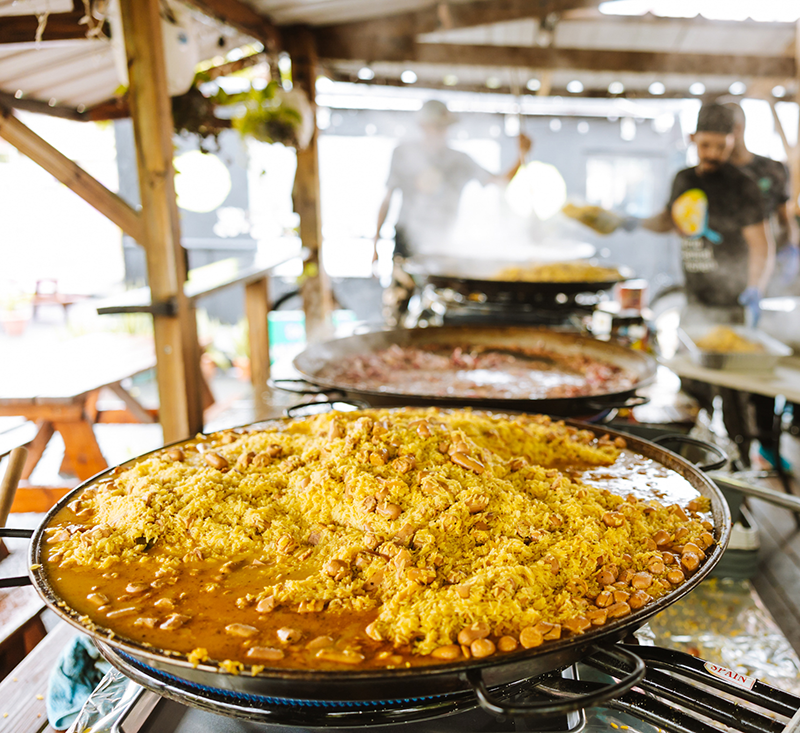 Large pan of food being cooked in an outdoor kitchen