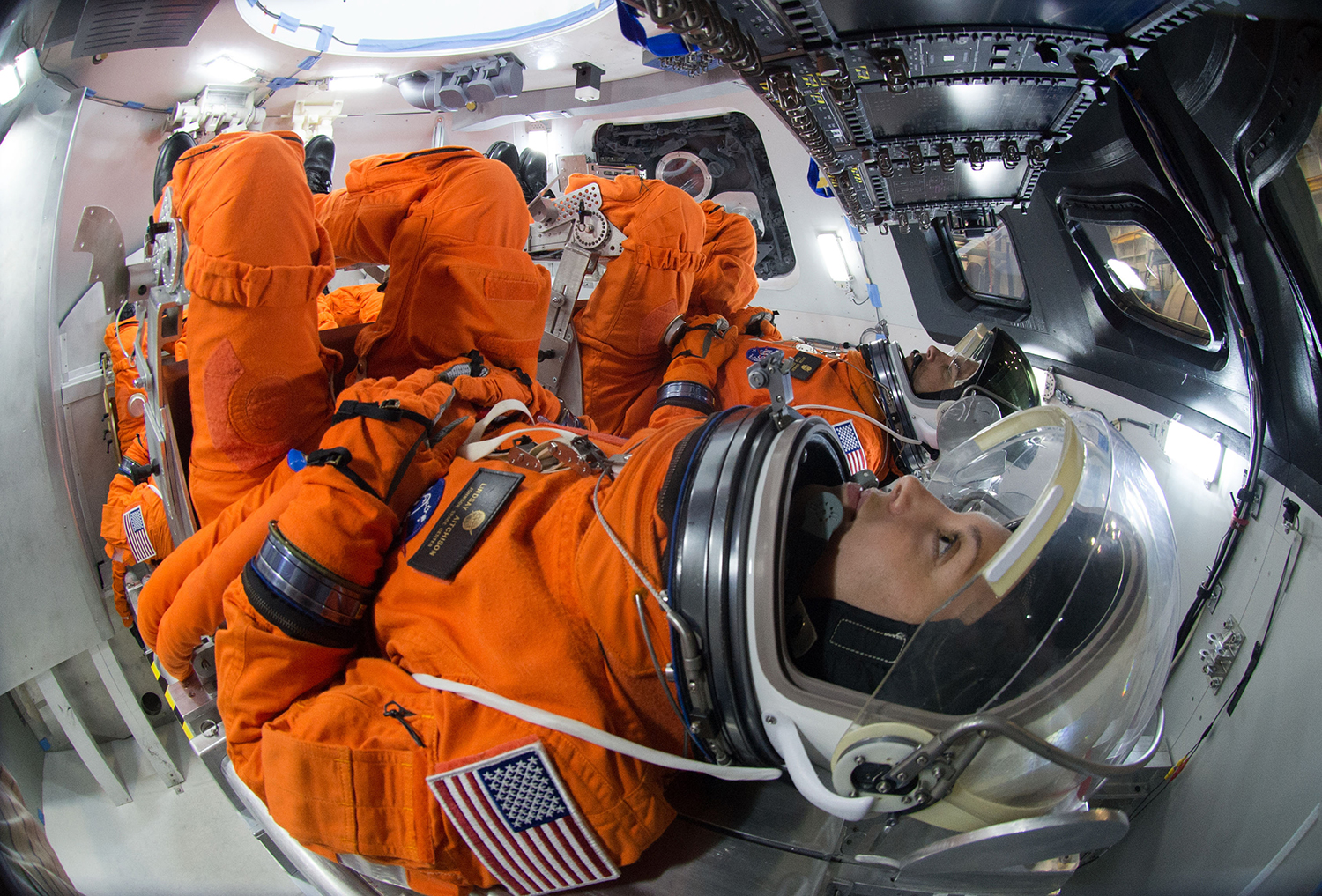Two astronauts sit in launch position inside capsule