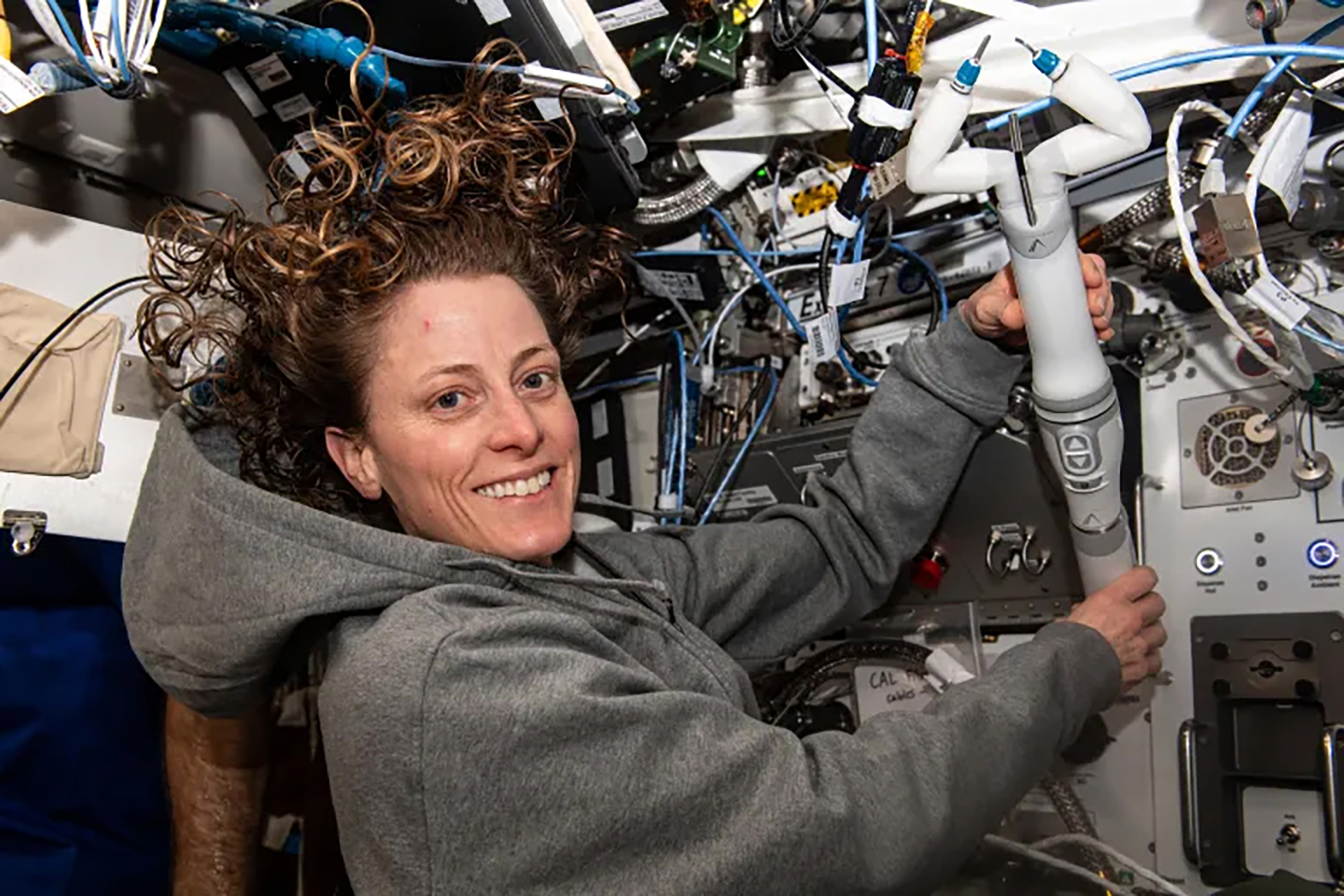Female astronaut floats in the ISS holding device