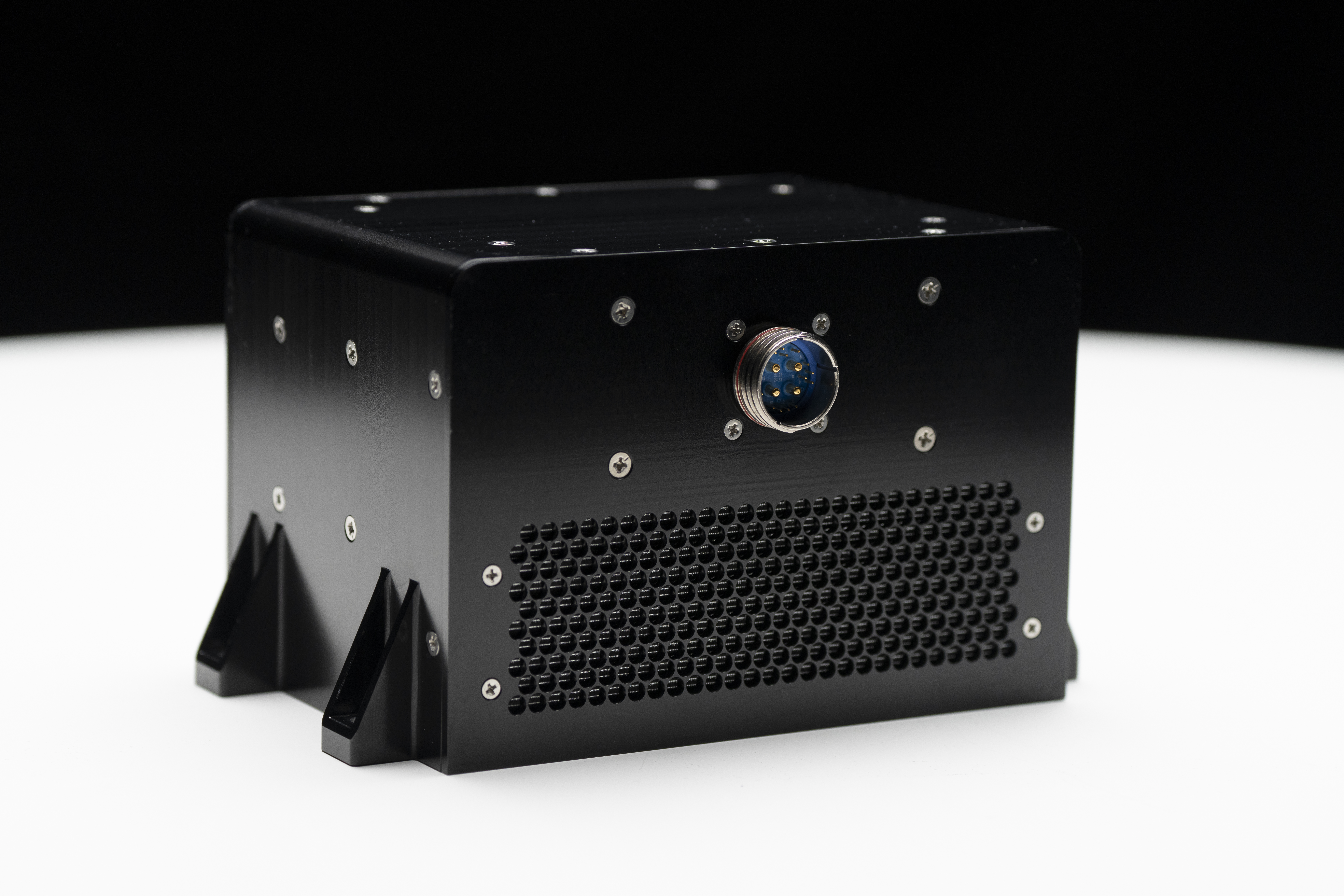 A black metal box covered in screws and with a single computer connector point.