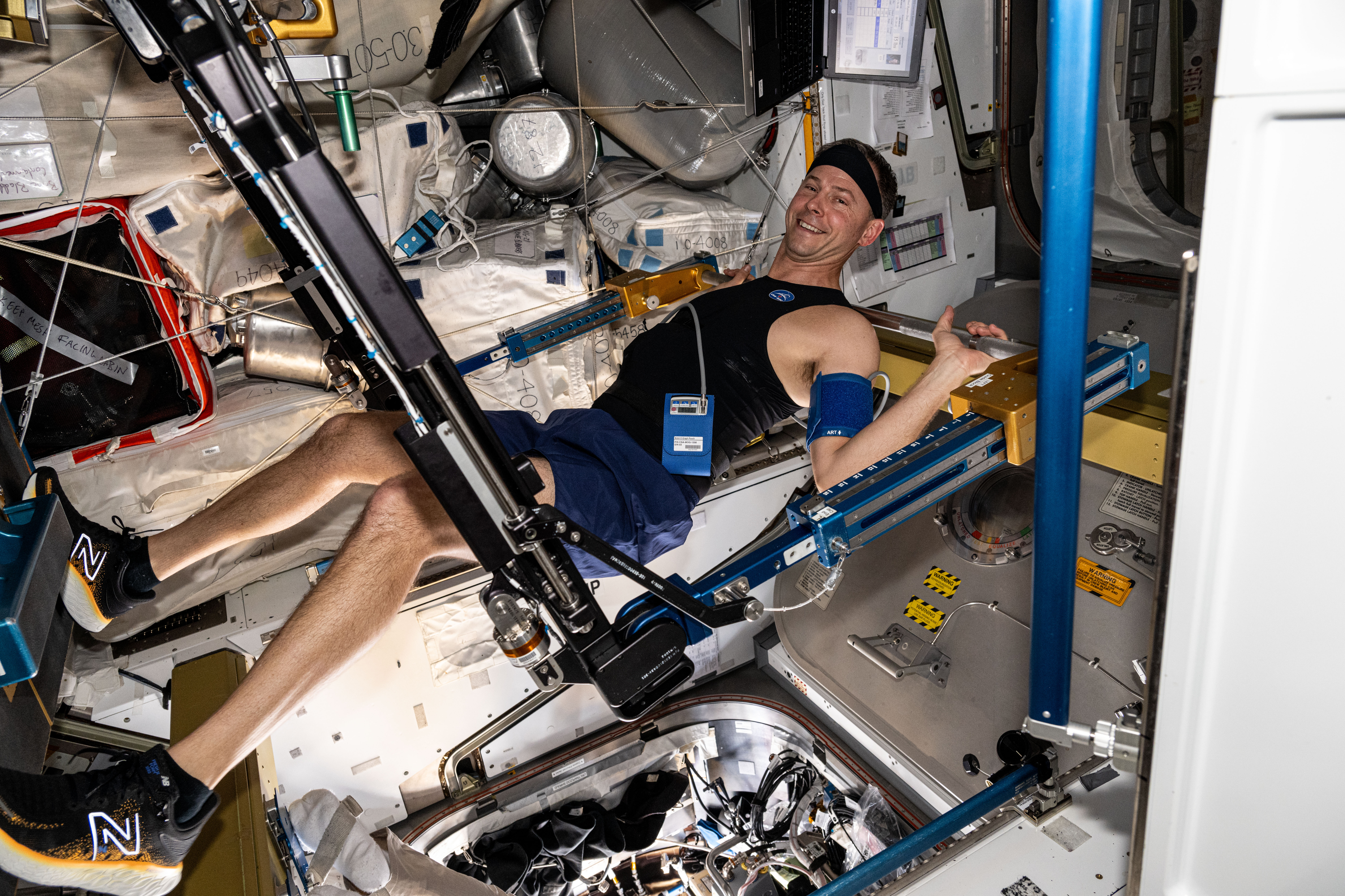 An astronaut in a specialized piece of exercise equipment aboard the International Space Station.