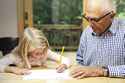 Man helping granddaughter with homework