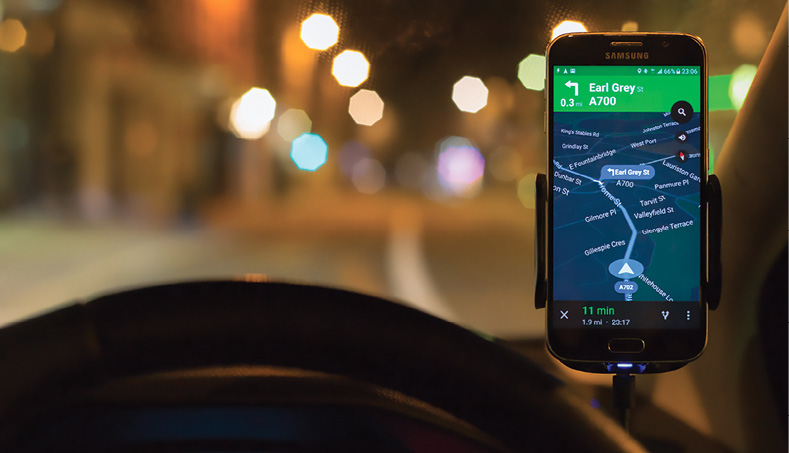 A smartphone mounted in a car gives directions