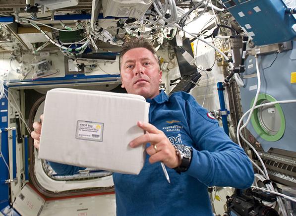 Italian astronaut Roberto Vittori holds up the Italian Electronic Nose for Space Exploration experiment aboard the space station