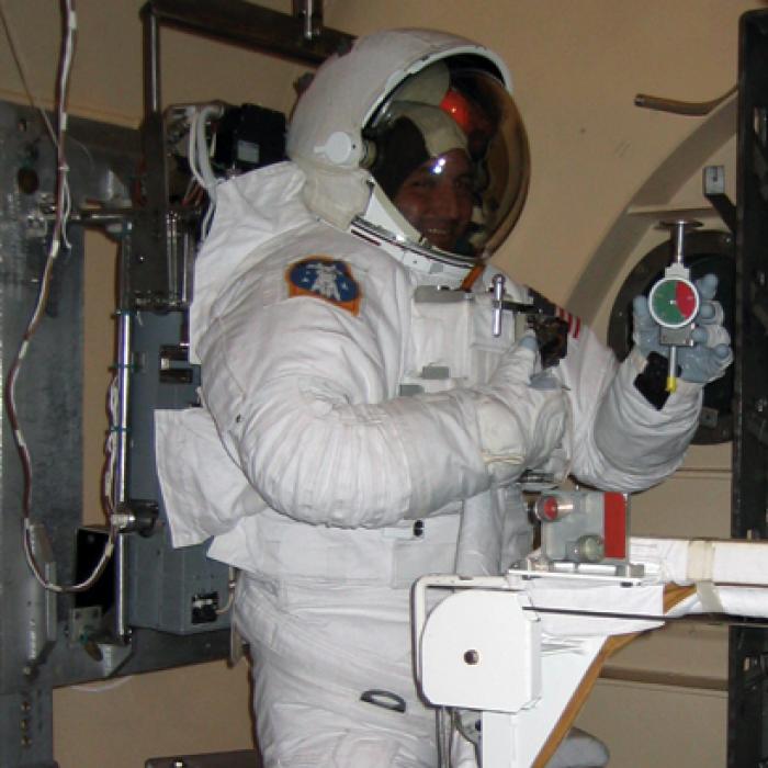 An astronaut displays the Rex Gauge durometer modified for space
