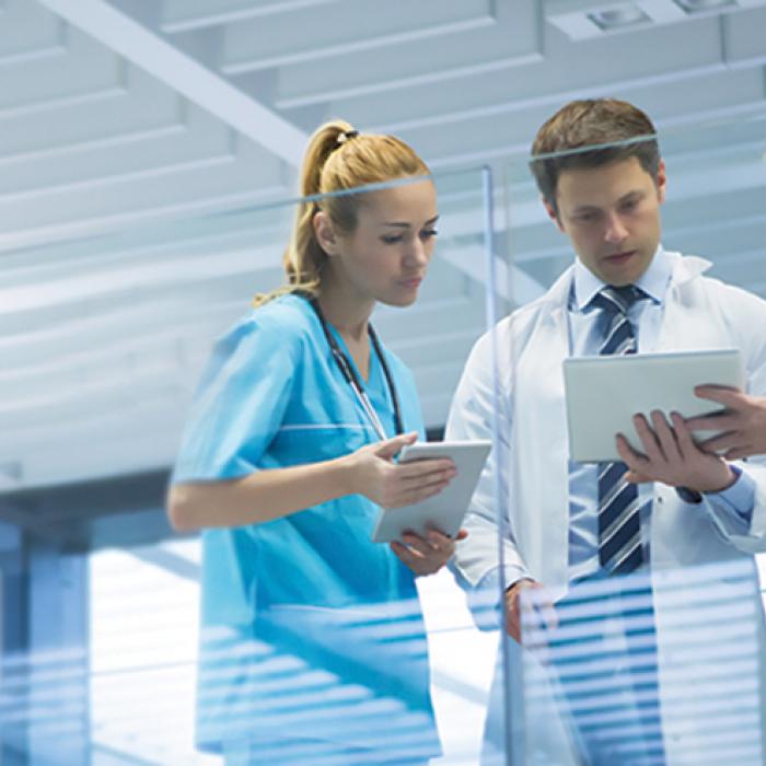 Doctors conferring while looking at a tablet computer