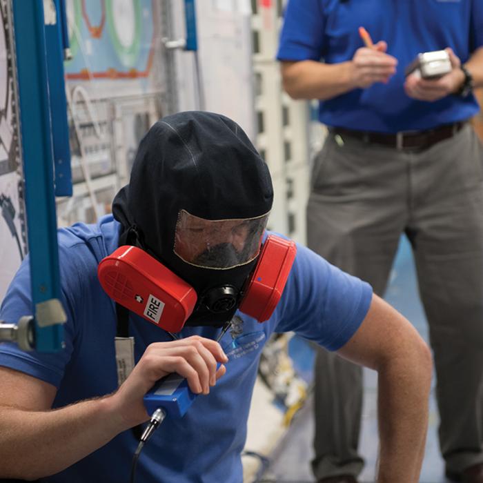 Two men wearing emergency breathing devices