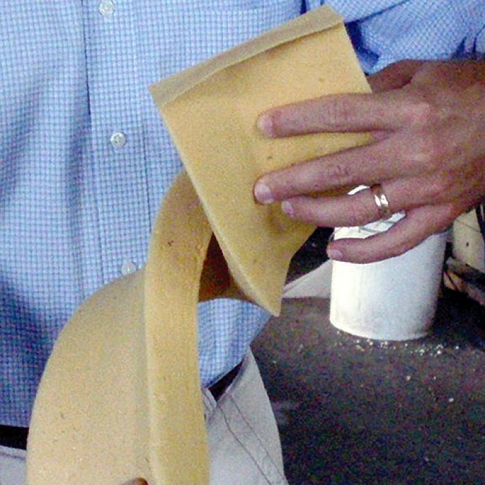 A man’s hands bend Polyshield foam, showing its flexibility, and a torch is applied to show its thermal strength 