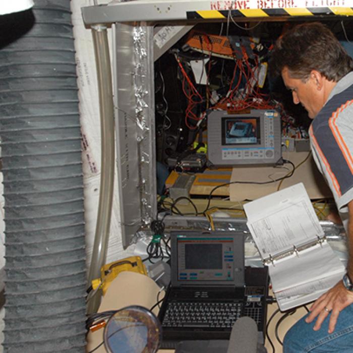Engineer testing wiring in the Space Shuttle Discovery