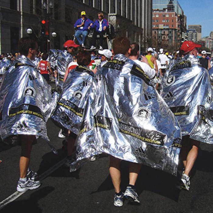 Marathon runners draped in reflective blankets to keep them warm