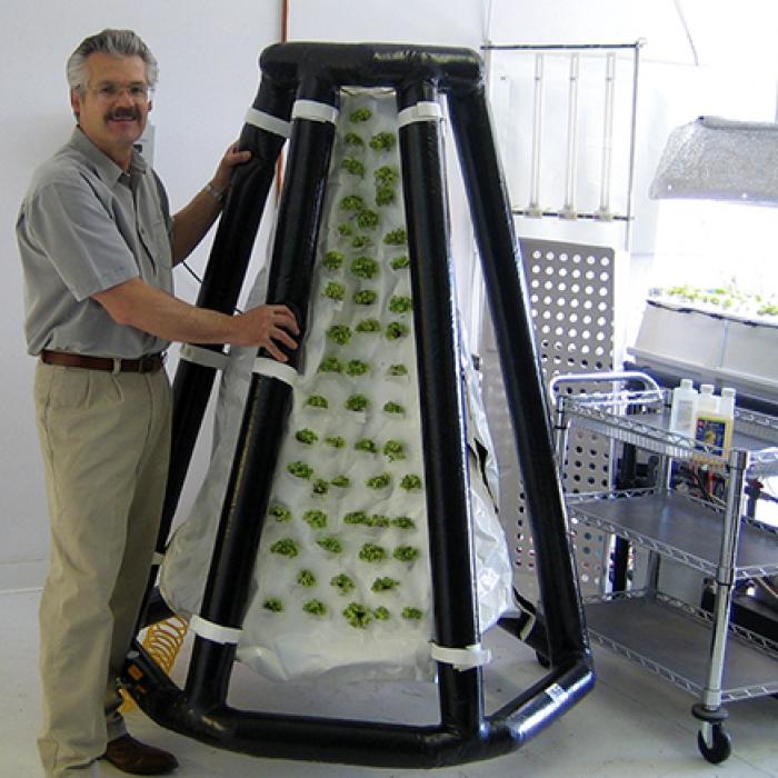 Richard Stoner II, the president of Agrihouse, next to an inflatable plant system