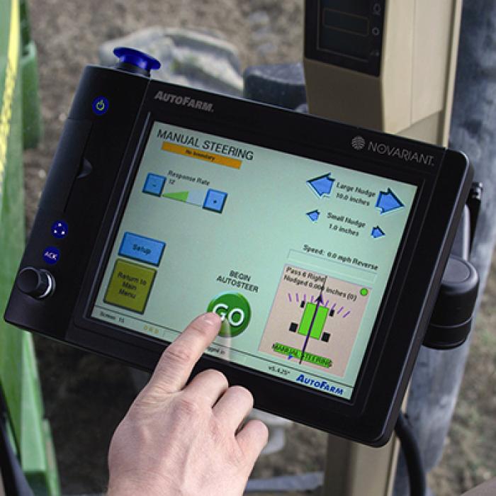 A farmer uses a touch screen console mounted on his tractor to control Auto steer