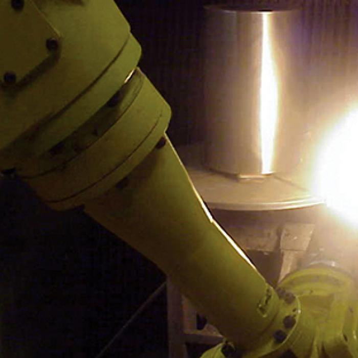 A spray gun applies a nano coating to a steel roller