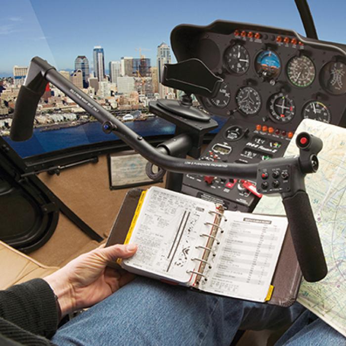 pilot with his hands off the controls while looking at maps