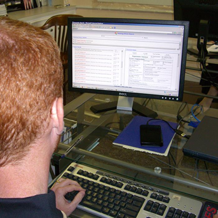 View over a user’s shoulder of AIOXFinder software displayed on a monitor