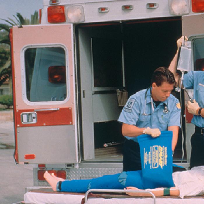 Two paramedics fit a shock victim with the Dyna Med anti-shock garment