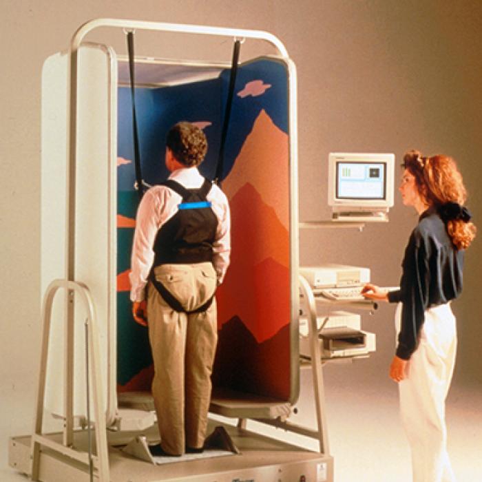A man stands in the EquiTest System sling while a technician stands at the controls
