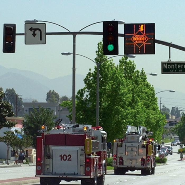 Emergency vehicles crossing intersection with LED displays above