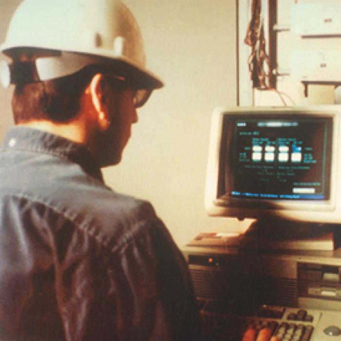 A plant technician checks an industrial process stream on a monitor