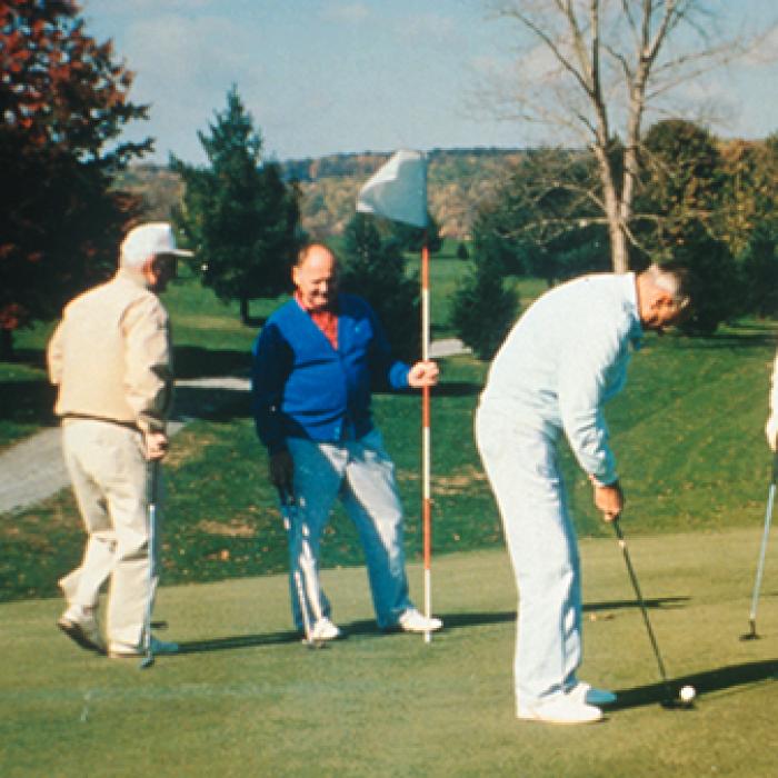 Four men playing golf on a golf course