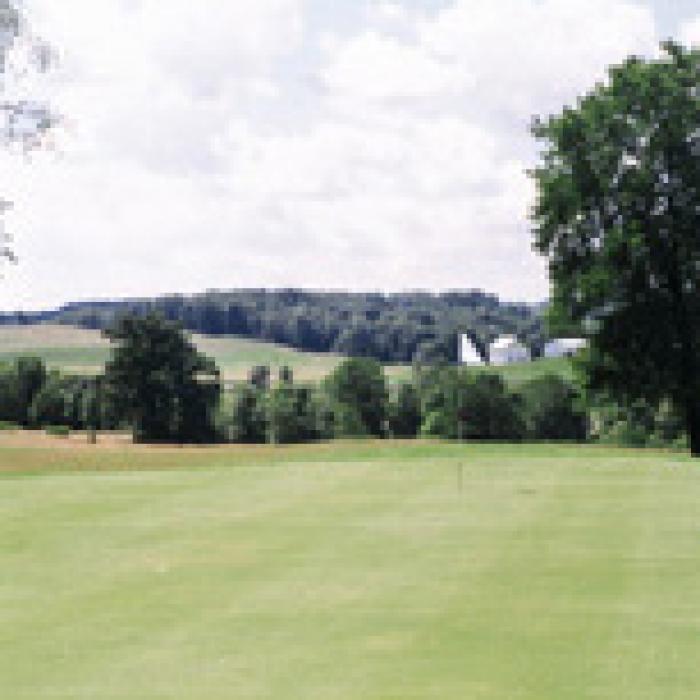 Golf club green with trees in background