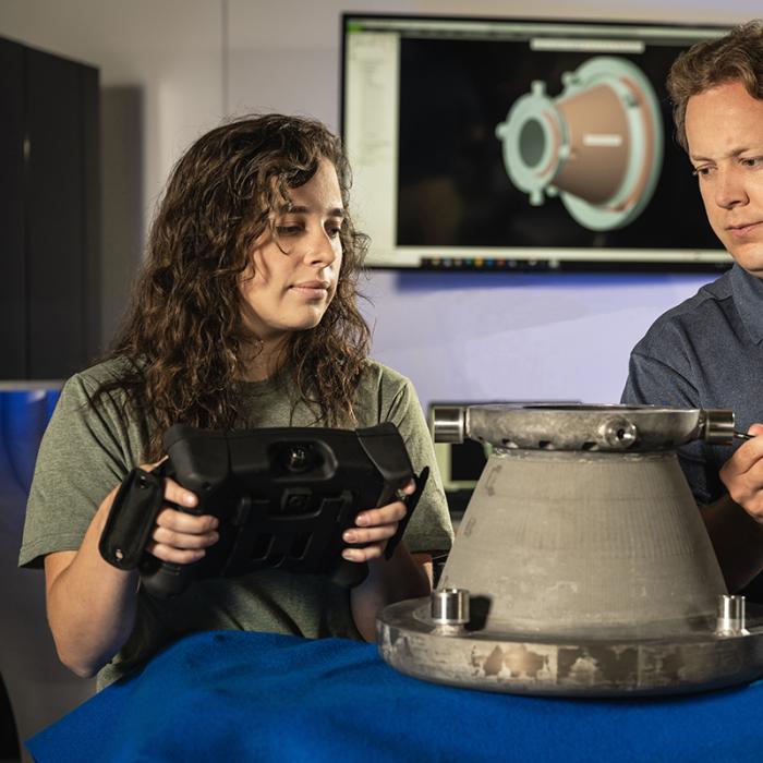 NASA engineers Tessa Fedotowsky and Ben Williams inspect a 3D printed aluminum nozzle