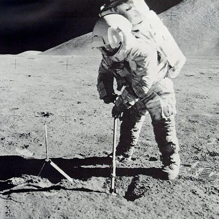 astronaut on moon scoops soil sample