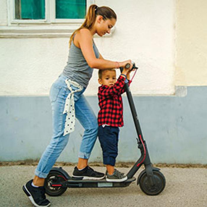A woman and a child  on an electric scooter